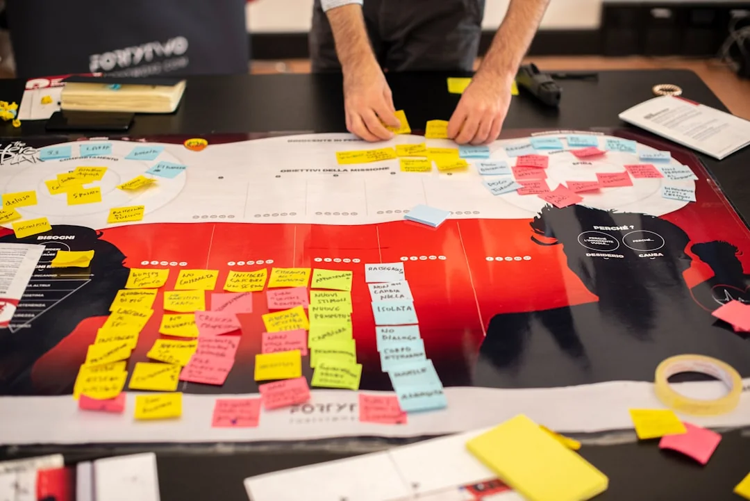Un espace de travail contemporain où des mains examinent des données marketing sur un ordinateur portable et des documents papier.